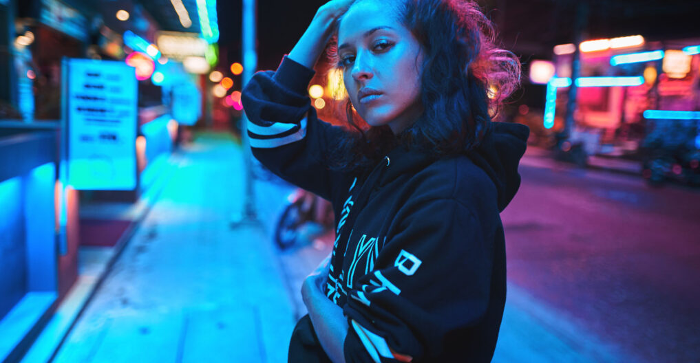 Neon close up portrait of young beautiful woman wear hoodie. night city street shot